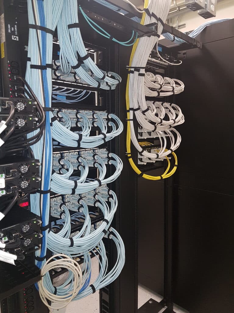 Neatly dressed network cabling bundles terminated into patch panels in a server rack