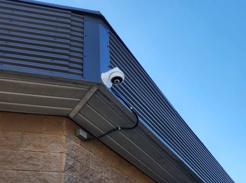 Turret security camera mounted under a commercial roofline